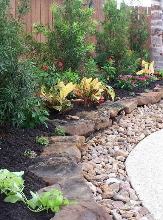 a large pebble and rough rock garden border brings much texture and a rough touch to the elegant outdoor space