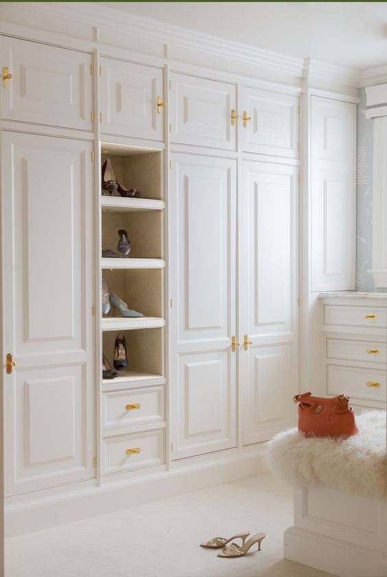 a neutral closet with gold hardware that adds chic and elegance to the space making it more welcoming