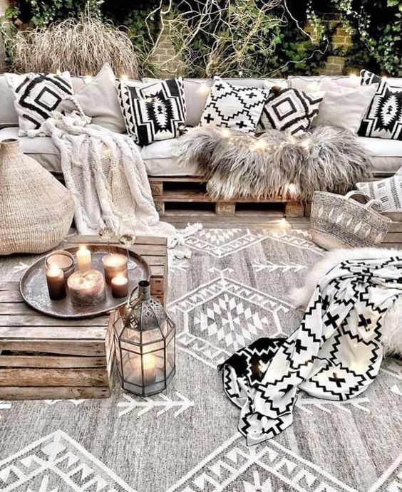 black and white pillows, a blanket and a matching rug in grey and white with tribal prints