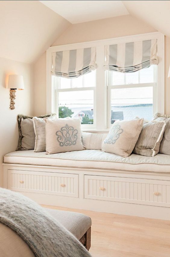 striped Roman shades in light blue and ivory add a vintage feel to the window nook and bring in a touch of subtle color