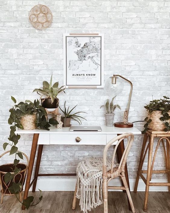 a boho chic home office nook with a whitewashed brick wall that creates a perfect backdrop and brings interest