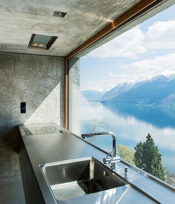 a kitchen with an unframed and uncovered view of a mountain lake inspires to create a culinary masterpiece