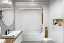 09 The bathroom is minimal and white, done with sleek surfaces, light wood touches and much storage space