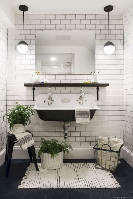 A vintage inspired powder room in black and white, with white subway tiles with black grout