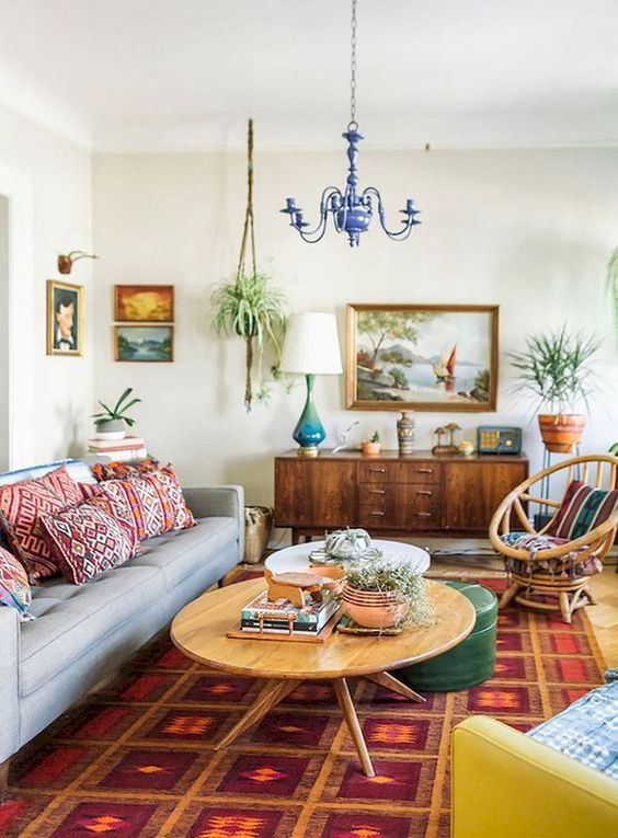 a boho meets mid-century modern living room with bright printed pillows, a rug and colorful furniture
