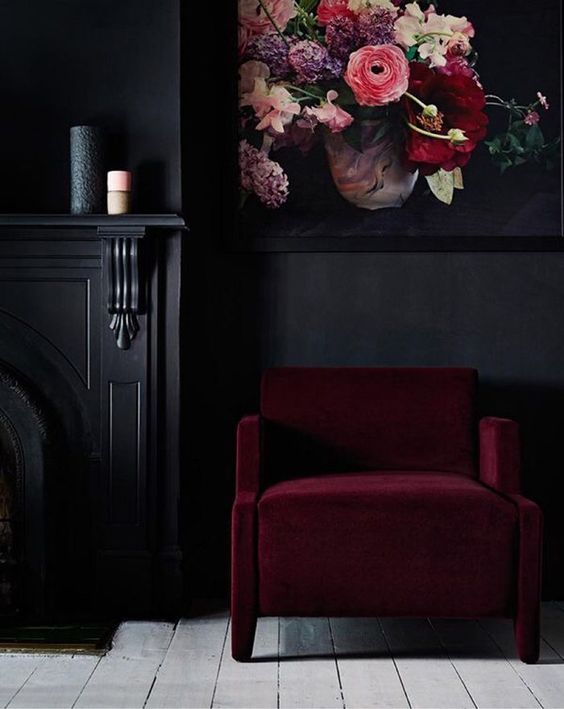 a moody nook spruced up with a bold florla artwork and a burgundy chair for more color