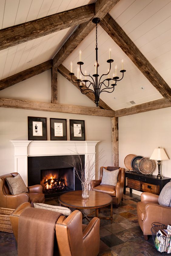 a warm-colored living room with brown leather furniture, a warm-colored rug and wooden beams