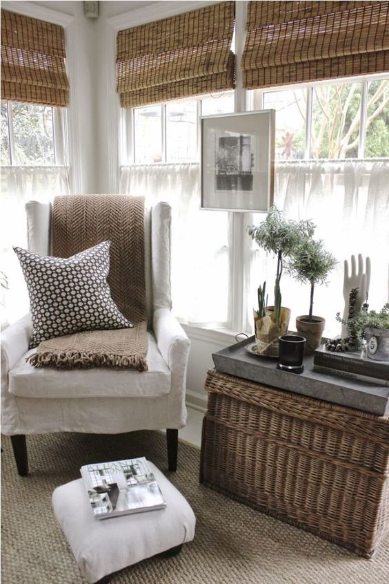 bamboo Roman shades, a basket as a coffee table and potted greenery bring an outdoor feel inside
