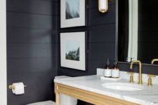 12 a chic and elegant bathroom with mosaic tiles, black shiplap walls, a light stained vanity and wall candle lanterns