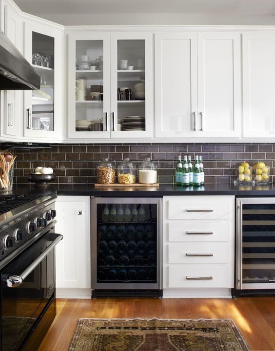 dark chocolate subway tiles with white grout make up a contrasting and bold kitchen backsplash