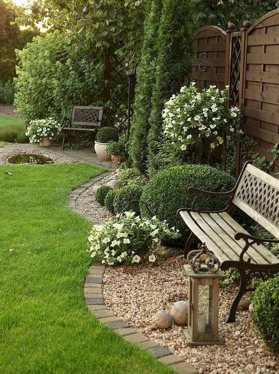 brick edging is timeless, here it divides the lawn and the pebble covered garden bed with a bench