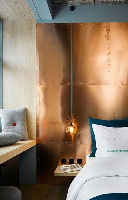 mixing cold and warm hues is a bodl idea, here a copper wall is paired with emerald bedding and grey pillows