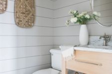 15 a fresh farmhouse bathroom with off-white shiplap, a wooden vanity, decorative baskets and touches of white