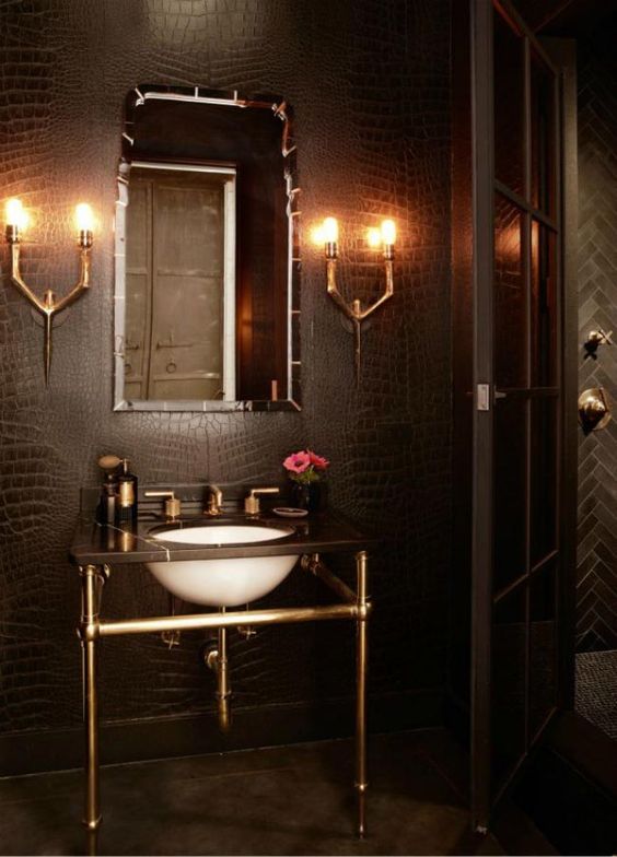 a small powder room lit up with wall lamps to make it brighter, fresher and more welcoming