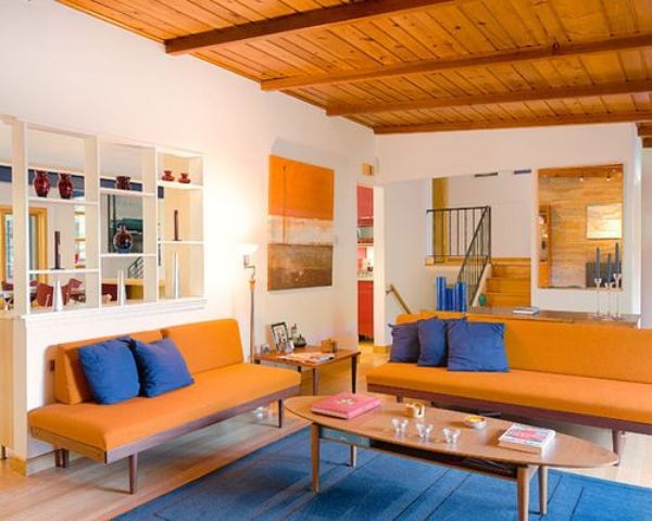 a super bright orange and blue living room calmed down with neutrals is a bold idea