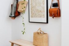 16 an artwork, a hanging planter with greenery and even a straw bag and hat add to the decor of the space