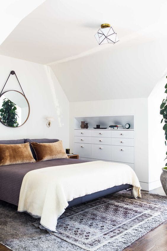 the bedroom is decluttered with some built-in storage units and additional negative space