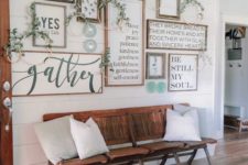 17 a cozy rustic gallery wall with greenery wreaths and decorative plates for a farmhouse entryway
