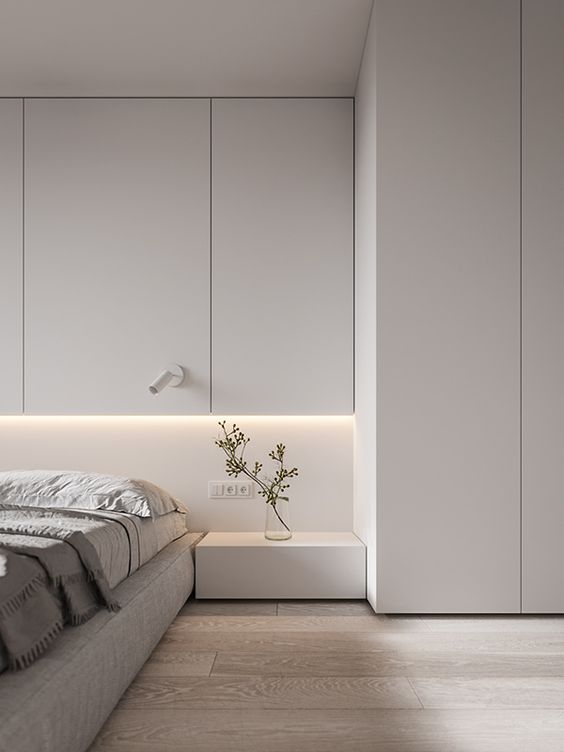 a contemporary meets minimalist bedroom with enough negative space and sleek whiet paneling