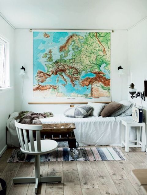 a vintage industrial guest bedroom with a large map as an artwork that inspires travelling