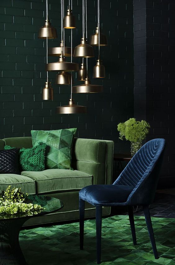 a refined living room with dark green, emerald and navy plus a cluster of brass pendant lamps