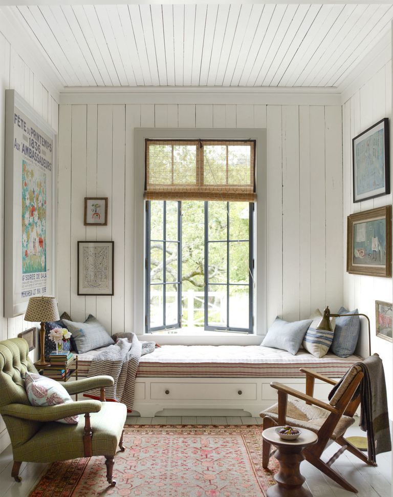 a very welcoming nook done with white shiplap on the walls and ceiling plus comfy vintage furniture