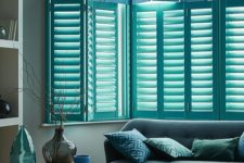 22 bay windows with blue plantation shutters is a chic and bold idea for a coastal or beach home