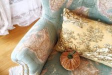 23 a map covered wingback chair with decorative nails detailing, a vintage pillow and a velvet pumpkin is very whimsy