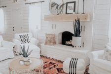 23 a welcoming white boho living room with white shiplap walls, a white brick fireplace and touches of rattan