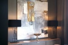 25 an oversized abstract artwork with touches of gold is a bright and chic idea to rock