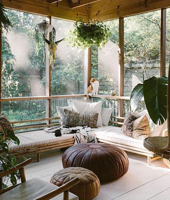 a sunroom with lots of potted greenery plus greenery outside create a cohesive space look