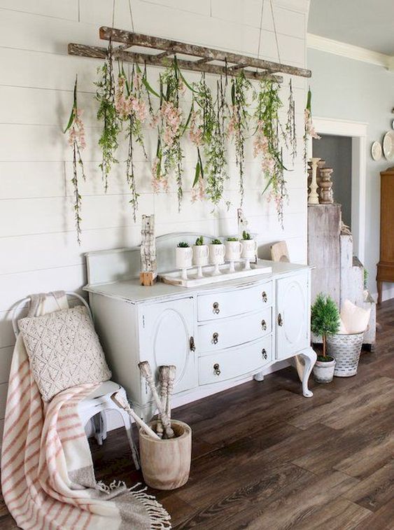 a vintage ladder with greenery and blooms plus potted plants make indoors feel like outdoors