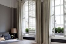 26 neutral shutters with matching curtains create a sophisticated and welcoming bedroom look adding charm to it