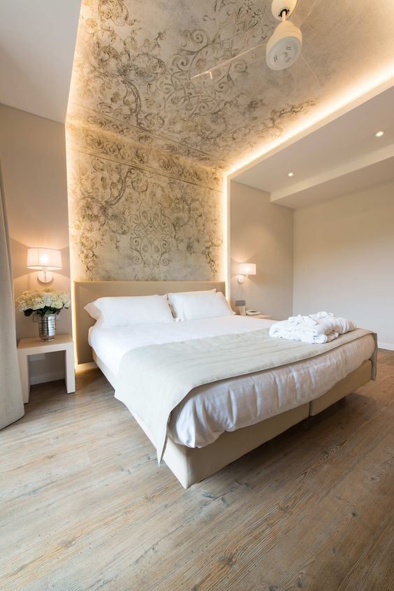 strip lighting integrated into the headboard wall and ceiling highlight the bed and make the space bolder