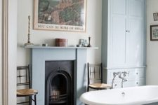 30 a vintage fireplace clad with blue and a mathcing tub and storage piece create a welcoming vintage bathroom