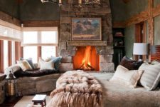 32 a cabin bedroom with a large stone clad fireplace that really warms up the space and makes it wow