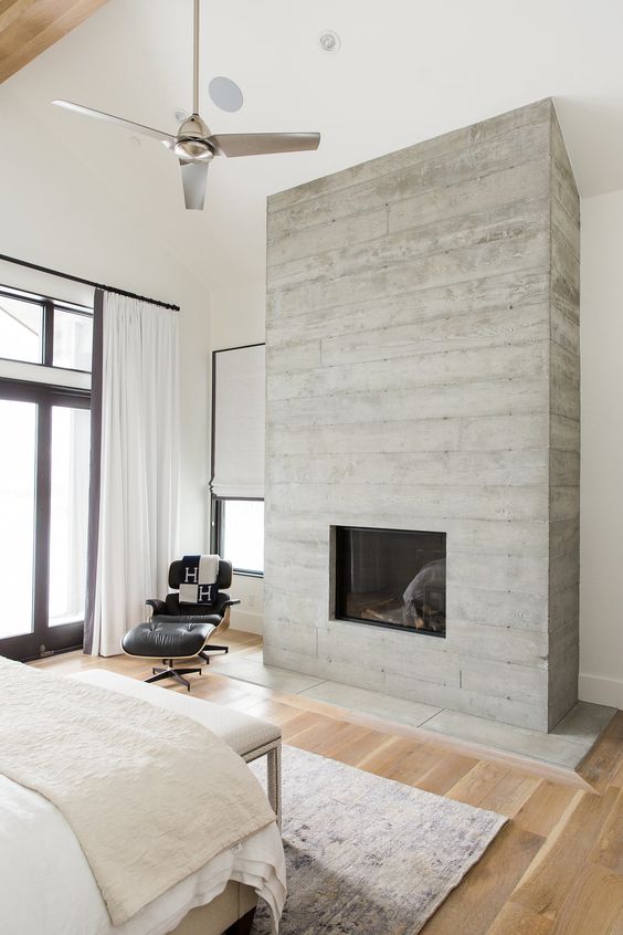 a built-in fireplace clad with weathered wood brings an inviting feel to the space and make it cozy
