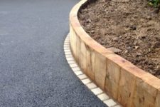 41 a tall wooden border for the raised garden bed and asphalt gardne pathways for an ultra-modern look