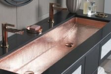 a double hammered copper sink with mathcing faucets and a soap dish spruce up the blakc vanity