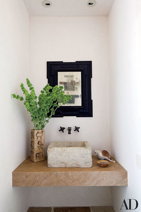 A rough stone square vessel sink on a stone built in vanity is a gorgeous idea for an Italin villa
