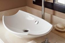 a stylish curved up white vessel sink adds a contemporary feel to the space with its curved corners