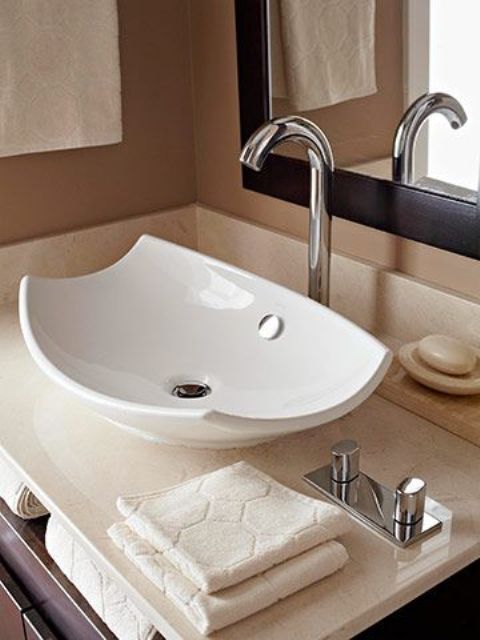 a stylish curved up white vessel sink adds a contemporary feel to the space with its curved corners