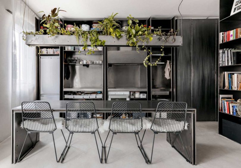 The kitchen is done with metal, all the appliances, a metal table and chairs plus a concrete planter over it