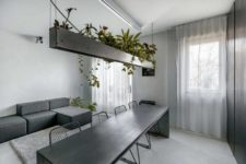 03 The living space continues the space with a laconic geometric sofa and potted plants