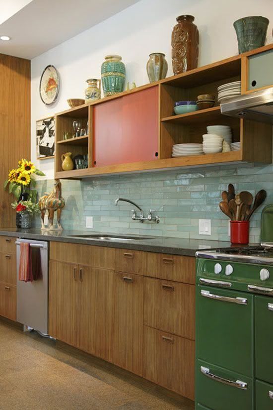 A bright mid century modern kitchen with red and green touches and mint green skinny tiles on the backsplash