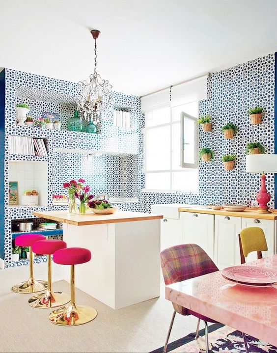 super bright pink stools with gold bases stand out in the blue and white kitchen and add a glam feel to the space