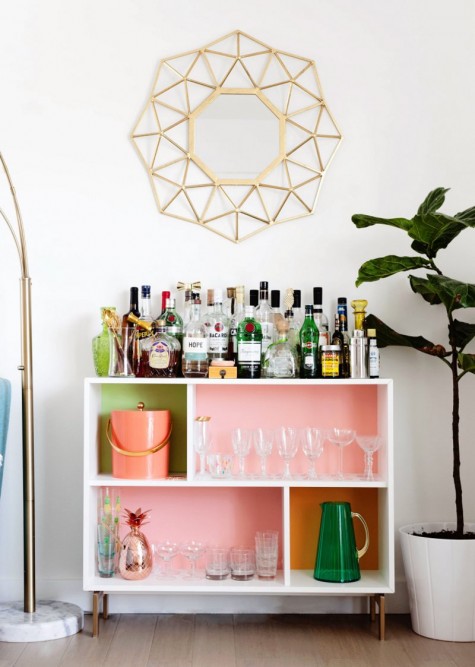 a bright home bar made of an IKEA Valje shelf with colored contact paper to spruce up the inside of each compartment
