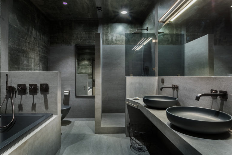 The bathroom is done with much concrete, stone and tiles, all in the shades of grey