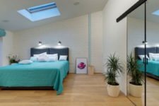 05 The master bedroom features a skylight, potted plants, a built-in storage unit with a mirror