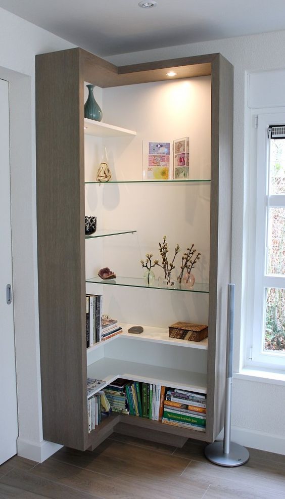 an open box shelving unit with sleek white and glass shelves located chaotically and with lights